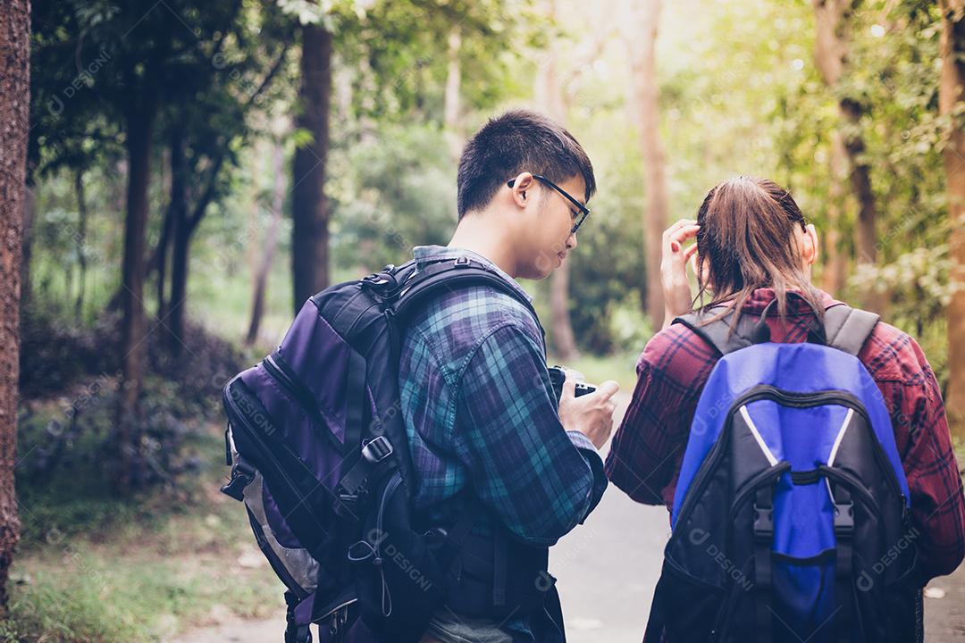 Grupo asiático de jovens Caminhando com mochilas de amigos caminhando juntos e olhando o mapa e tirando a câmera