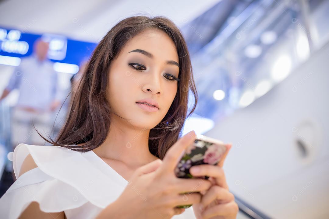 Empresários e mulher da Ásia estão usando telefone inteligente móvel e sensível ao toque para comunicação