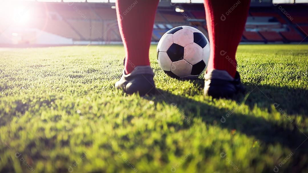 jogador de futebol ou futebol em pé com bola no campo para chutar a bola de futebol no estádio de futebol