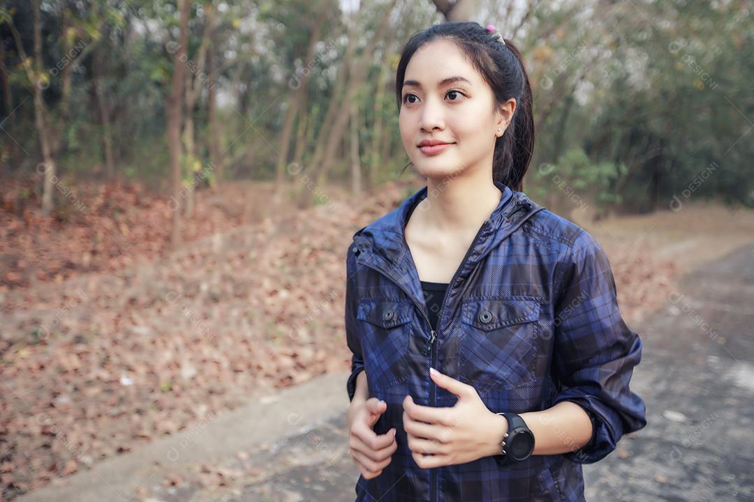 Mulher asiáticas correndo e correndo ao ar livre na estrada no parque