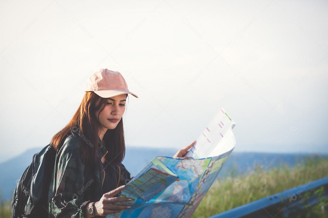 Mulher jovem asiática caminhando com mochilas de amigos caminhando juntos e olhando o mapa e tirando a câmera