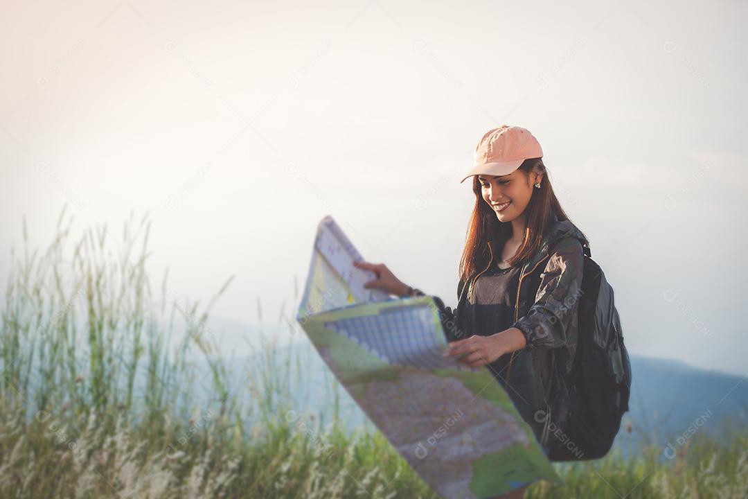 Mulher jovem asiática caminhando com mochilas de amigos caminhando juntos e olhando o mapa e tirando a câmera