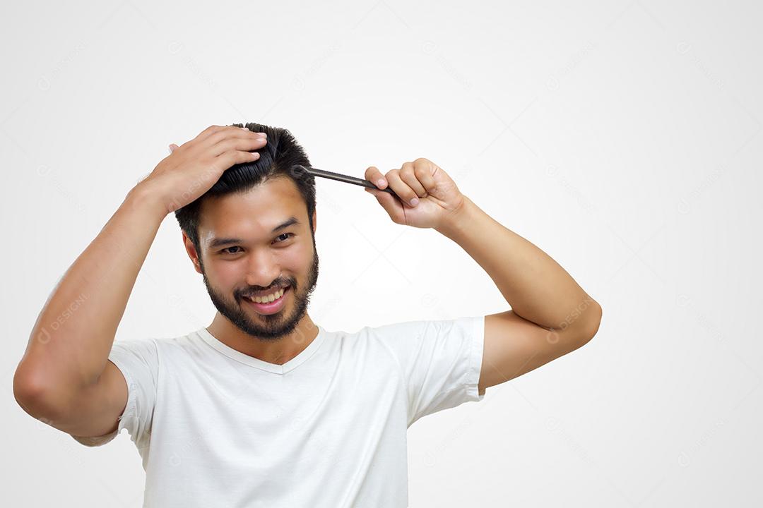 conceito de pessoas - jovem sorridente, escovando o cabelo com pente no fundo branco