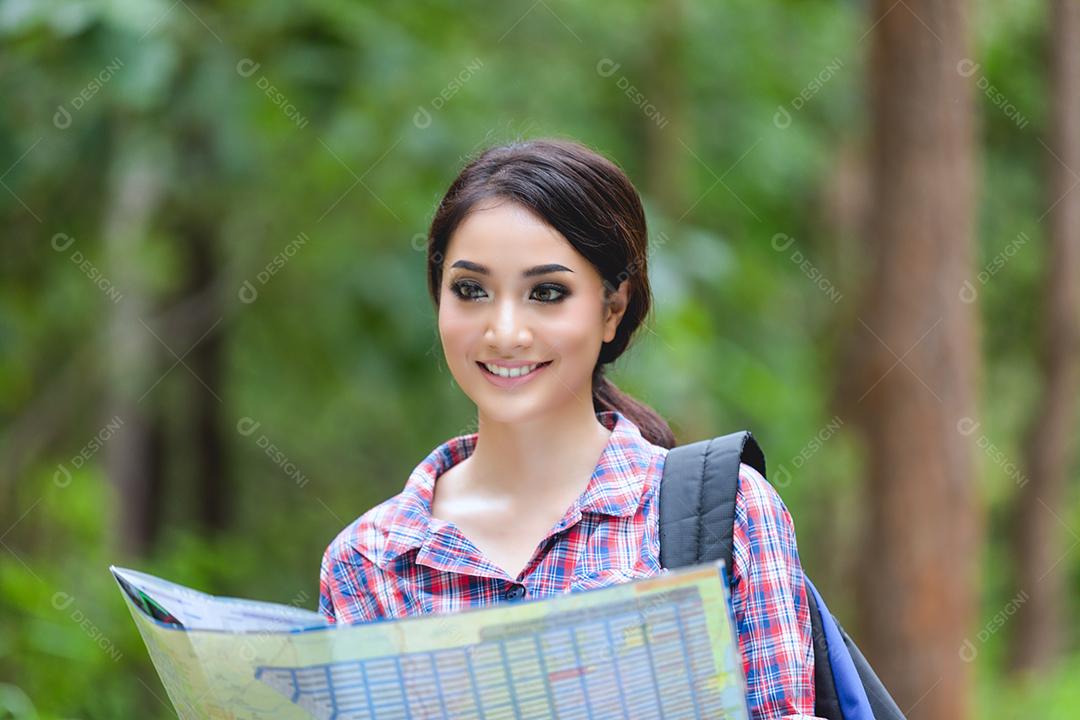 Young hiker looking at map and relaxing time on forest vacation concept travel