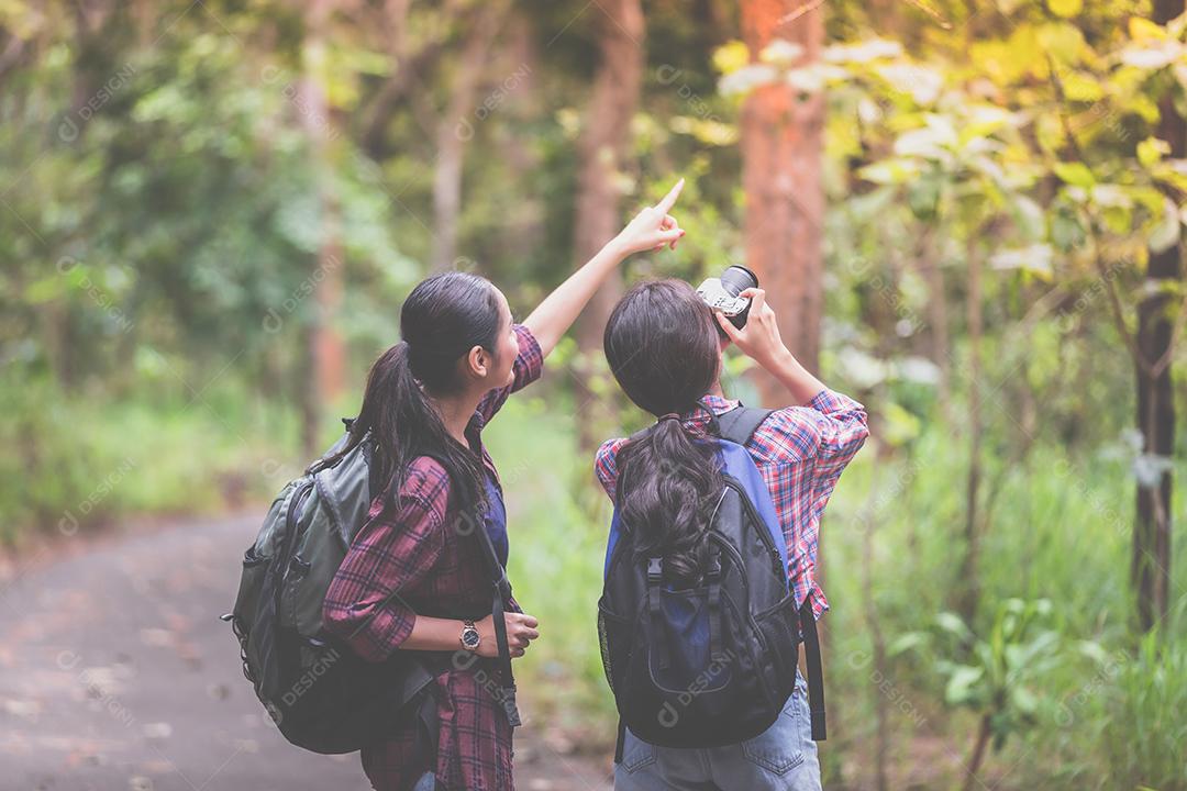 Grupo asiático de jovens Caminhando com mochilas de amigos caminhando juntos e olhando o mapa e tirando a câmera fotográfica