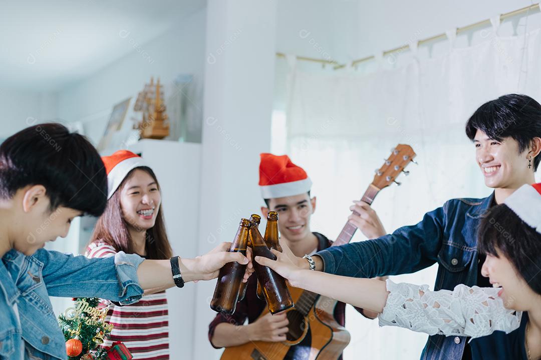 Grupo asiático de amigos festejando com bebidas alcoólicas de cerveja e jovens se divertindo em um bar brindando coquetéis.