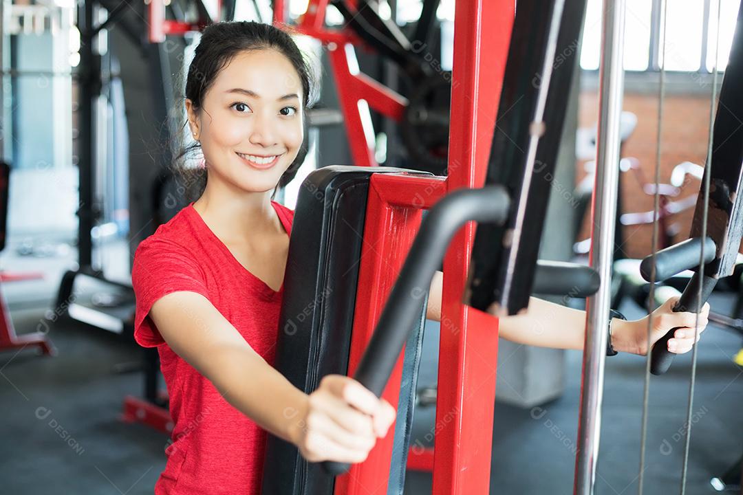 Mulher apto muscular exercitando a construção de músculos e fitness mulher fazendo exercícios no ginásio. Aptidão