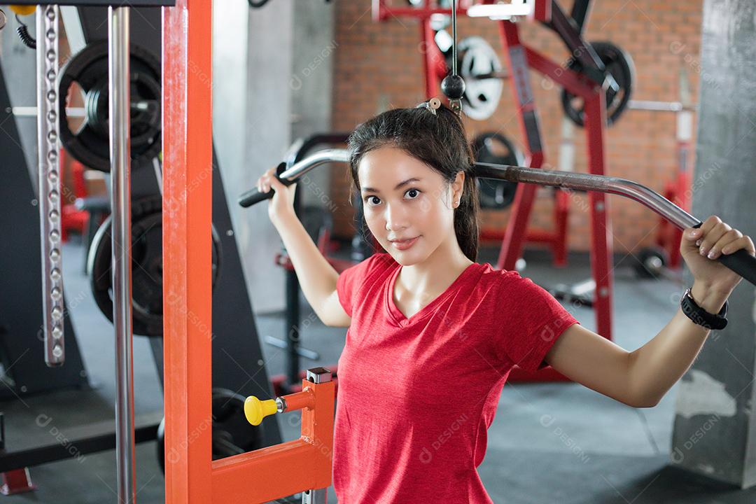 bela mulher apto muscular exercitando a construção de músculos e fitness mulher fazendo exercícios no ginásio