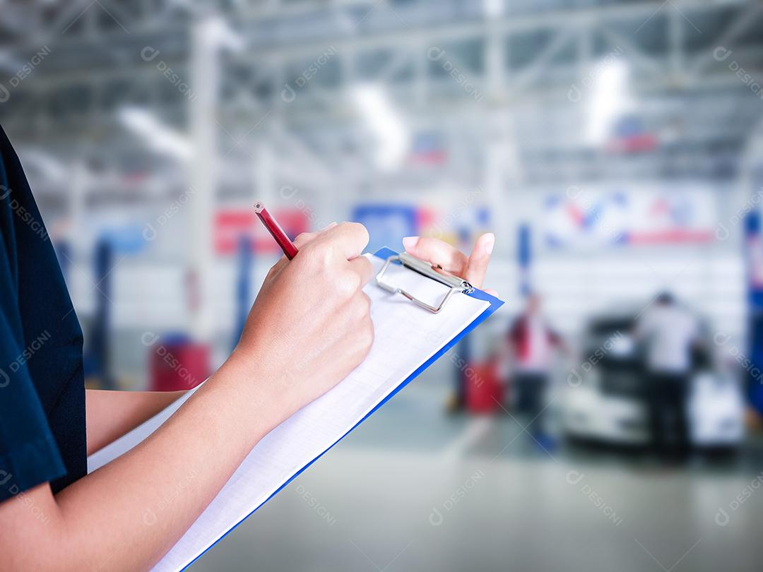 Engenheiras e técnicas asiáticas estão verificando o mecânico e inspecionando um carro na oficina de automóveis a lista no quadro