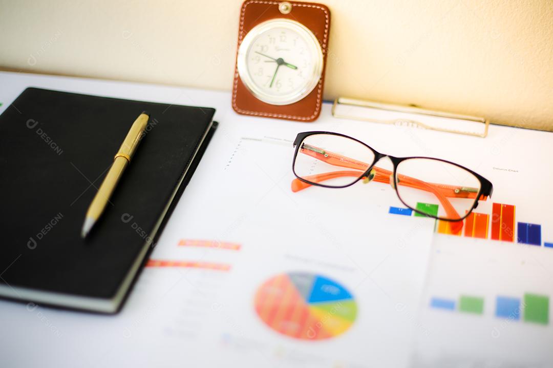 Conceito de negócios de gráficos de trabalho e análise de escritório e relógio na mesa
