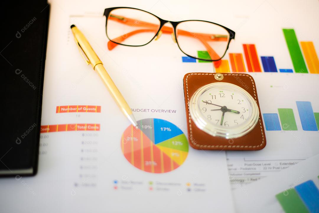 Conceito de negócios de gráficos de trabalho e análise de escritório e relógio na mesa