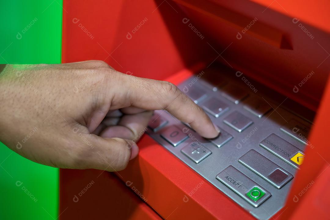 Mão de homem digitando o código PIN/senha no teclado da máquina ATM/banco