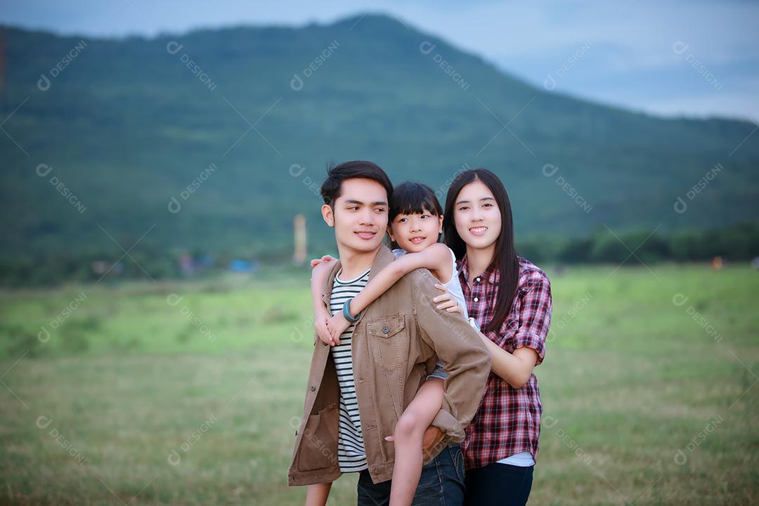 Família asiática e a criança senta-se nos ombros de seu pai e filhas de filhos se divertindo e brincando