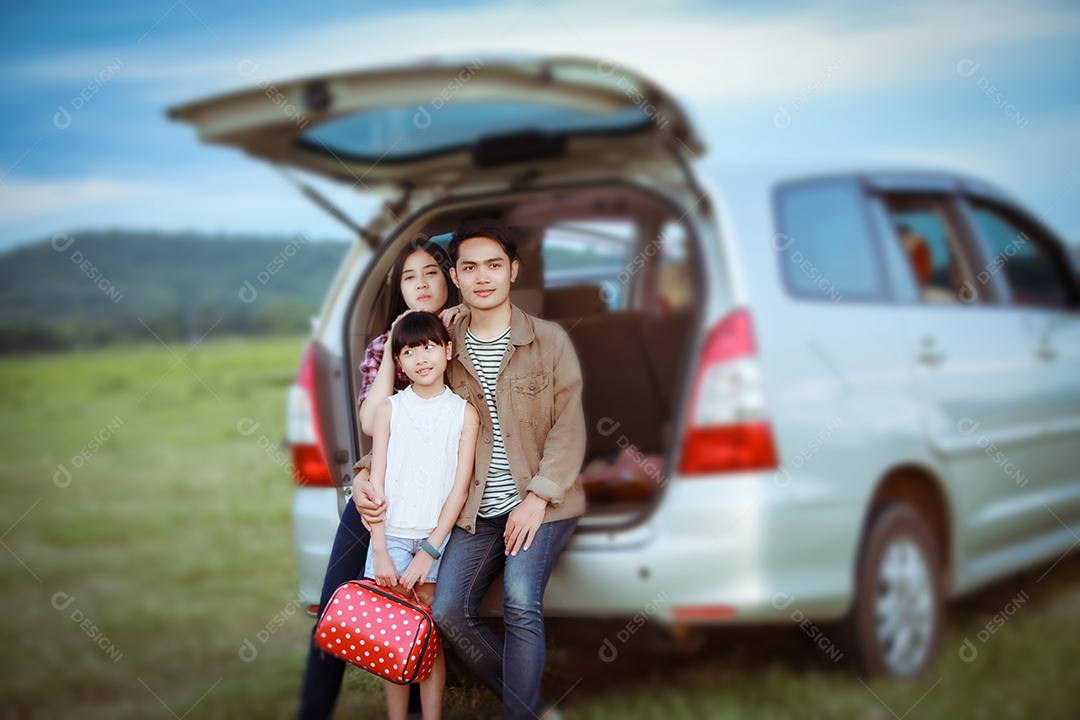 Menina feliz com família asiática sentada no carro para curtir a viagem e as férias de verão na van campista