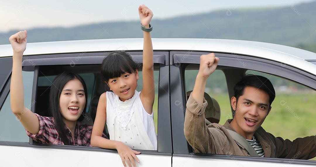 Menina feliz com família asiática sentada no carro para curtir a viagem e as férias de verão na van campista