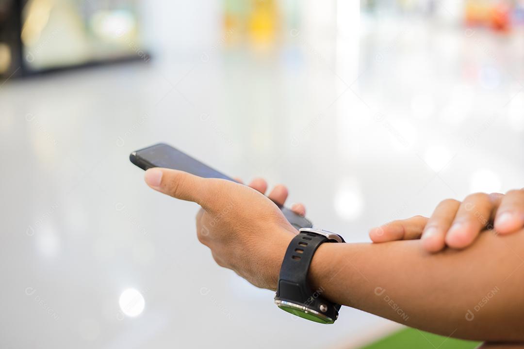 Homem asiático usando telefone para celular e mensagens de texto em seu celular