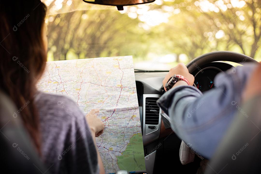 Homem e mulher asiáticos usando mapa na viagem e casal jovem feliz com um mapa no carro.
