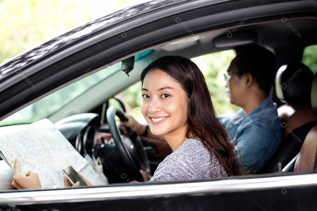 Mulher asiática usando smartphone e mapa e homens dirigindo carro em viagem e jovem casal