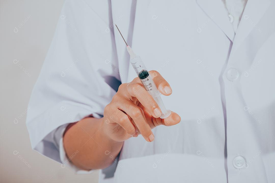 Médico segurando seringa de injeção médica e equipamento de vacinação de plástico de medicina com agulha. Enfermeira ou médico. Droga líquida ou narcótico. Cuidados de saúde no hospital.