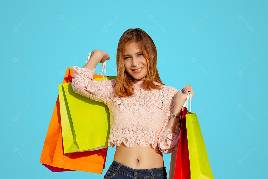 Mulher asiática e linda garota estão segurando sacolas de compras sorrindo enquanto fazem compras