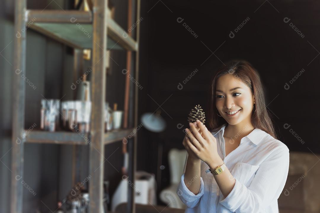 Mulher asiática sorrindo e felizes Relaxando em uma cafeteria depois de trabalhar em um escritório de sucesso.