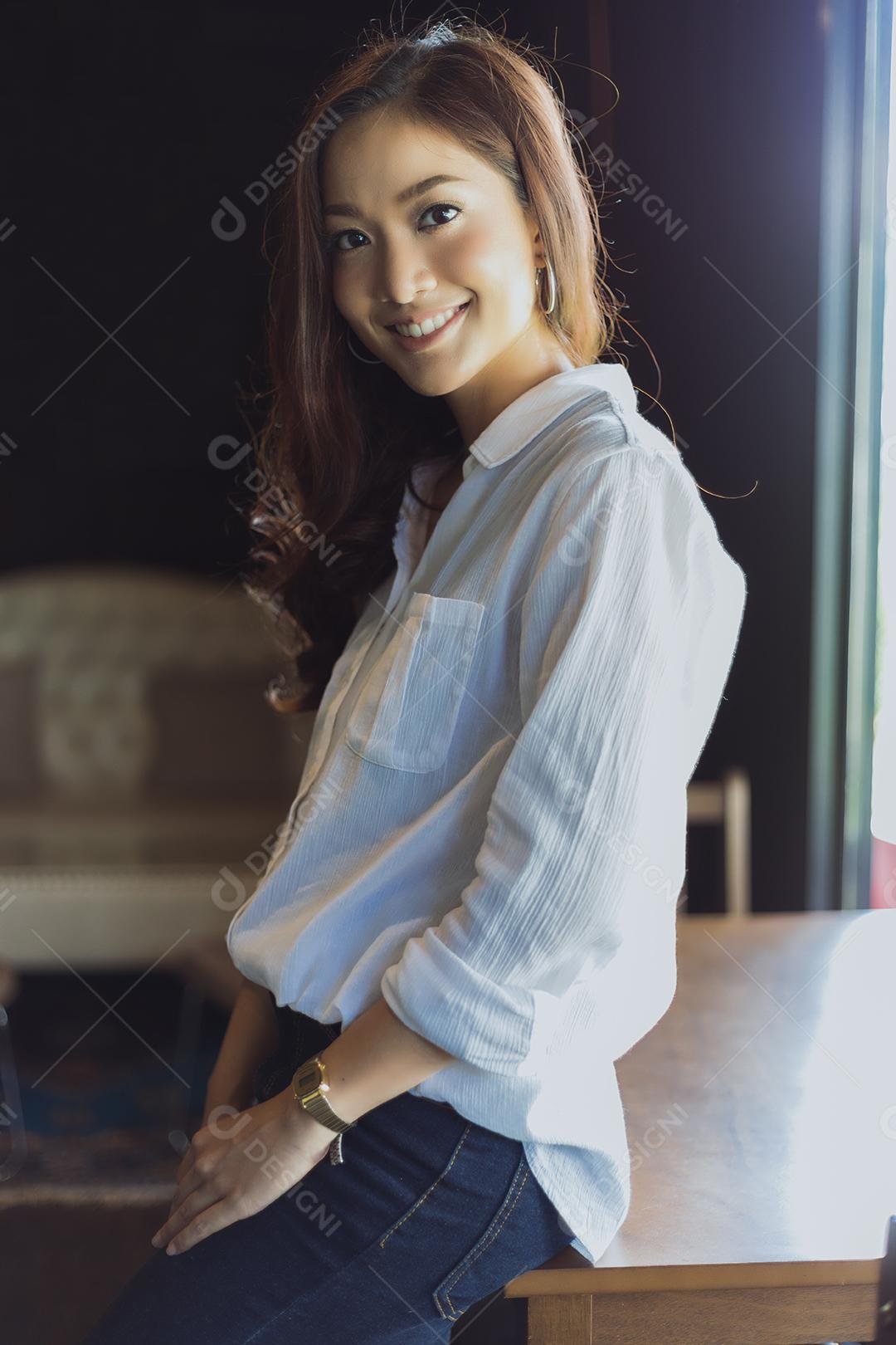 Asian woman smiling and happy Relaxing in a coffee shop after successful office work.