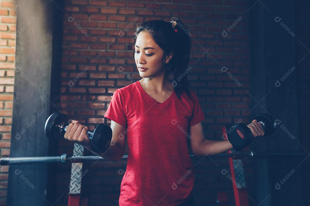 bela mulher apto muscular exercitando a construção de músculos e fitness mulher fazendo exercícios no ginásio