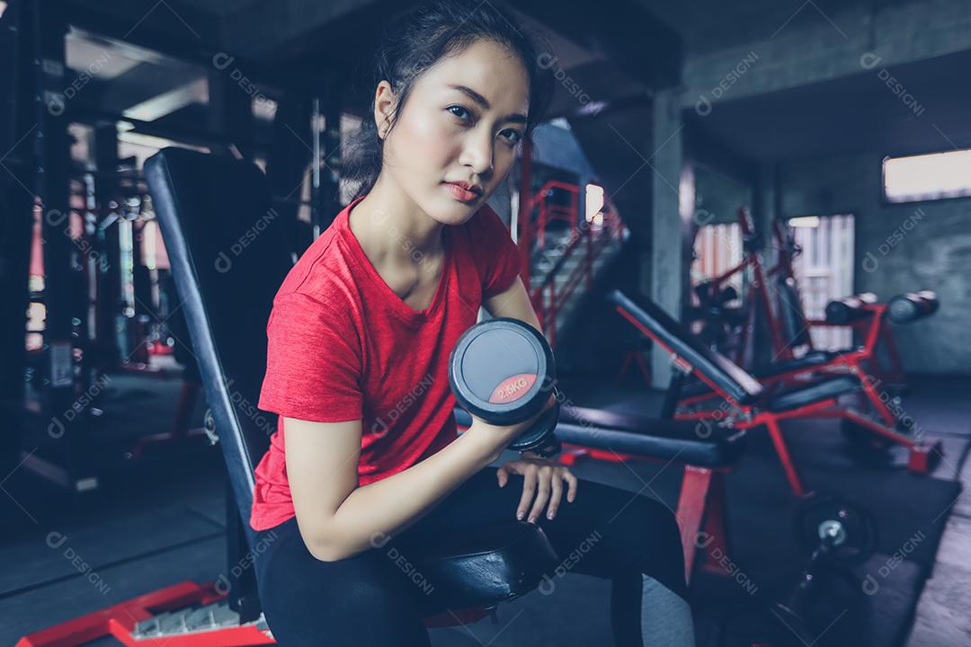 bela mulher apto muscular exercitando a construção de músculos e fitness mulher fazendo exercícios no ginásio