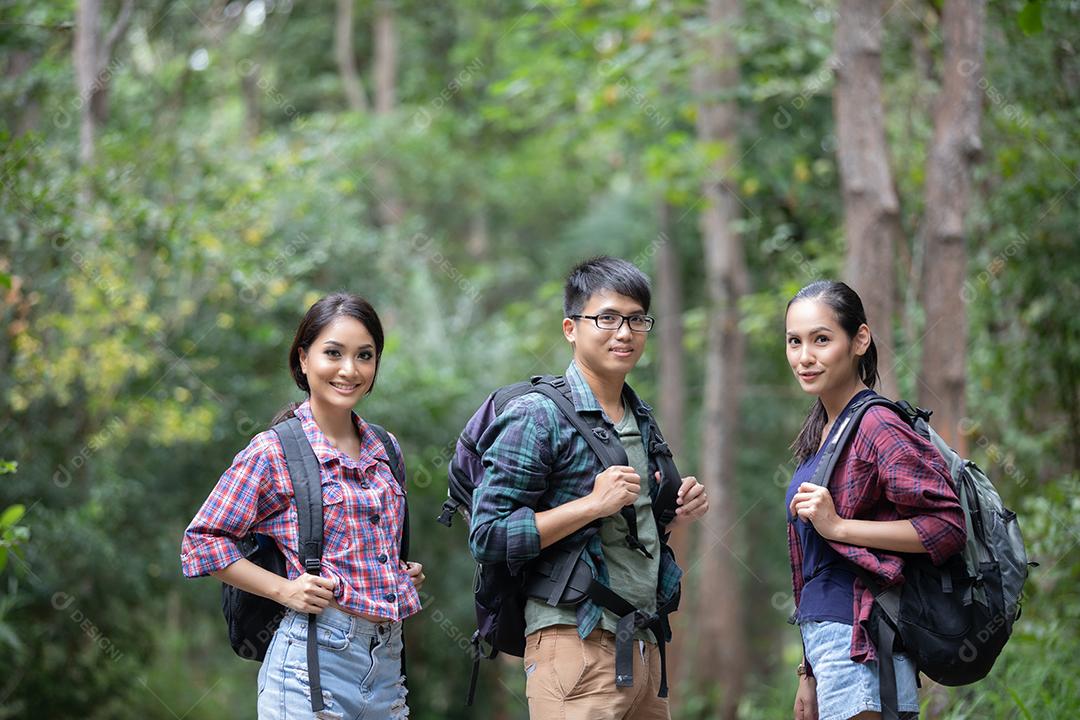 Grupo asiático de jovens Caminhando com mochilas de amigos caminhando juntos e olhando o mapa e tirando a câmera