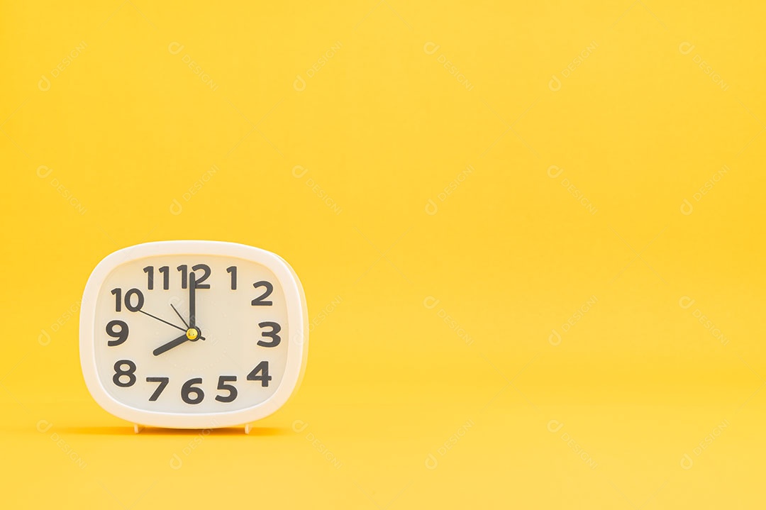 Relógio contra um fundo amarelo