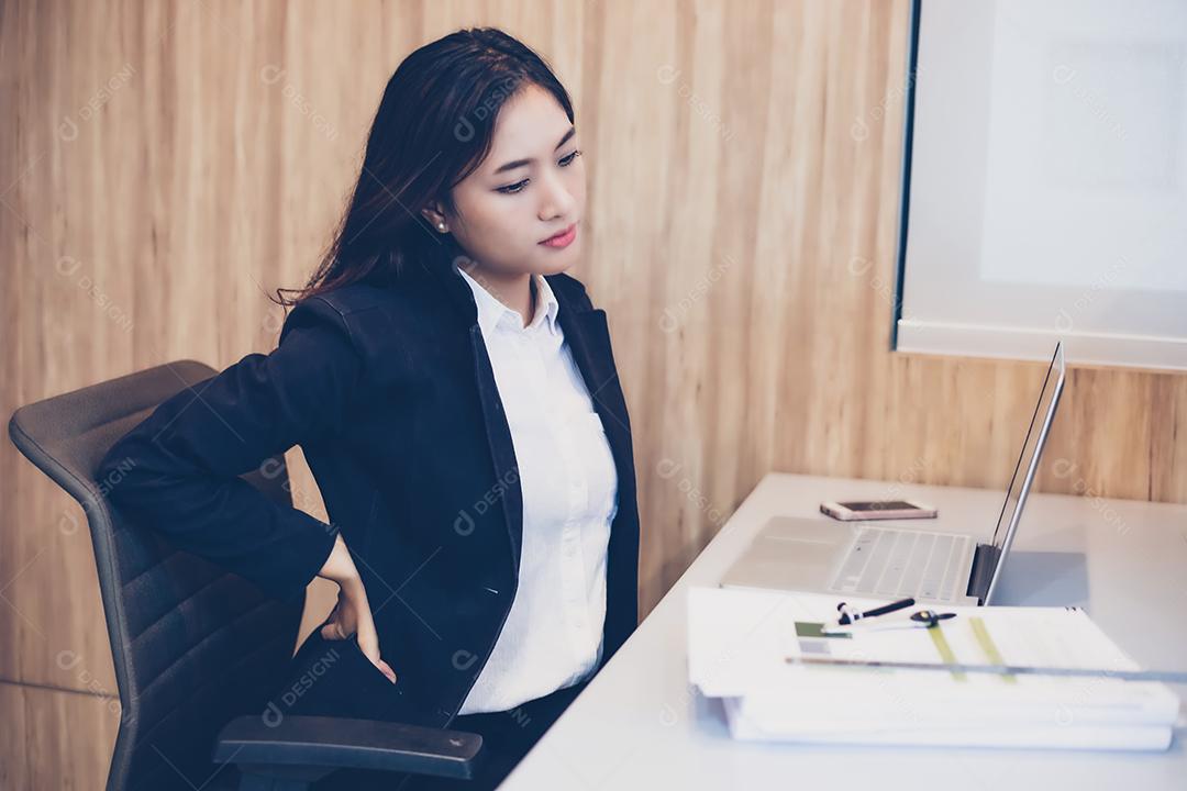 Empresária asiática se estendendo depois de trabalhar duro no escritório