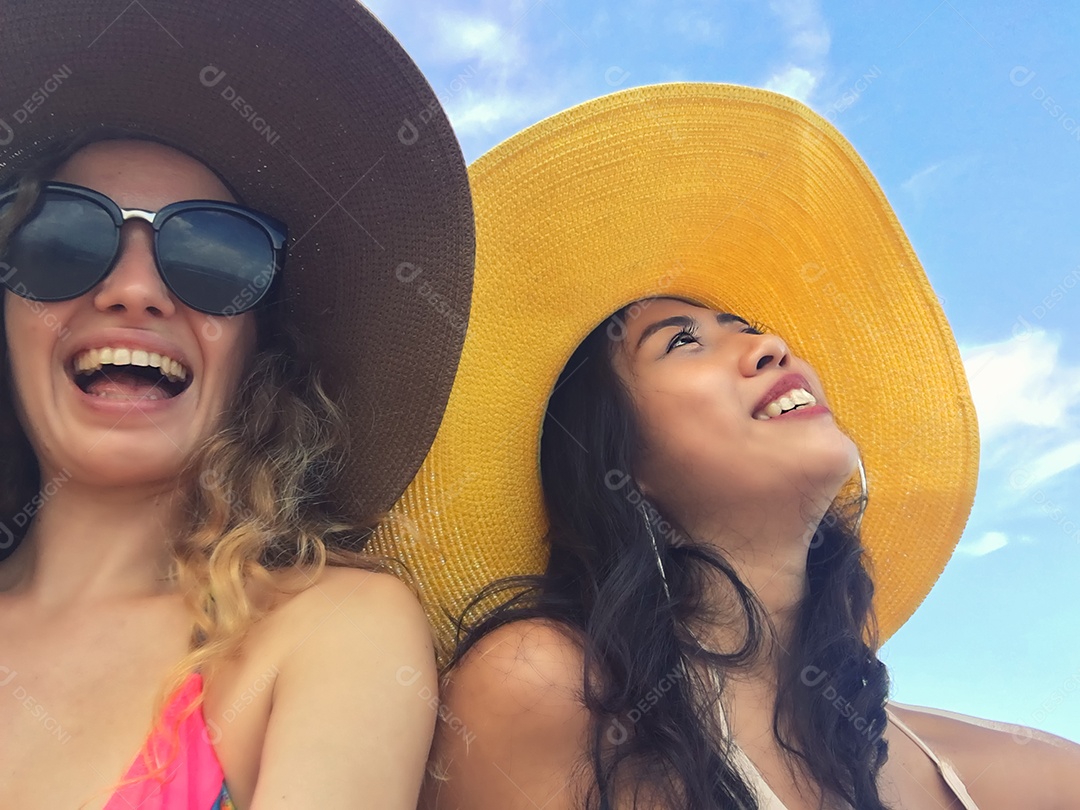 As mulheres estão tirando fotos e selfie com amigos na praia de areia