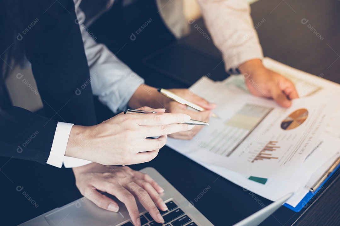 Mulheres de negócios asiáticas segurando uma caneta e documentos de análise