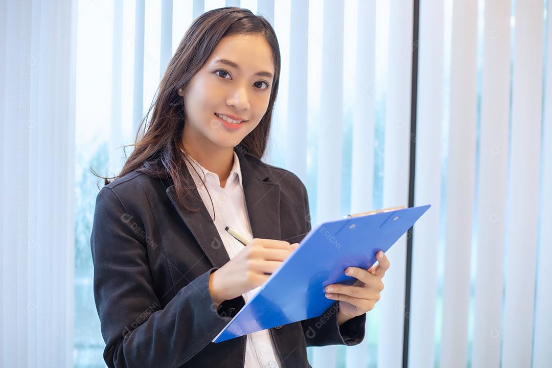 Mulher de negócios asiática sorrindo felizes por trabalhar e verificar documentos