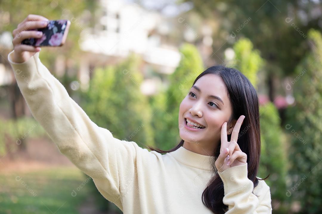 Mulher asiática sorrindo estão tirando fotos e selfie