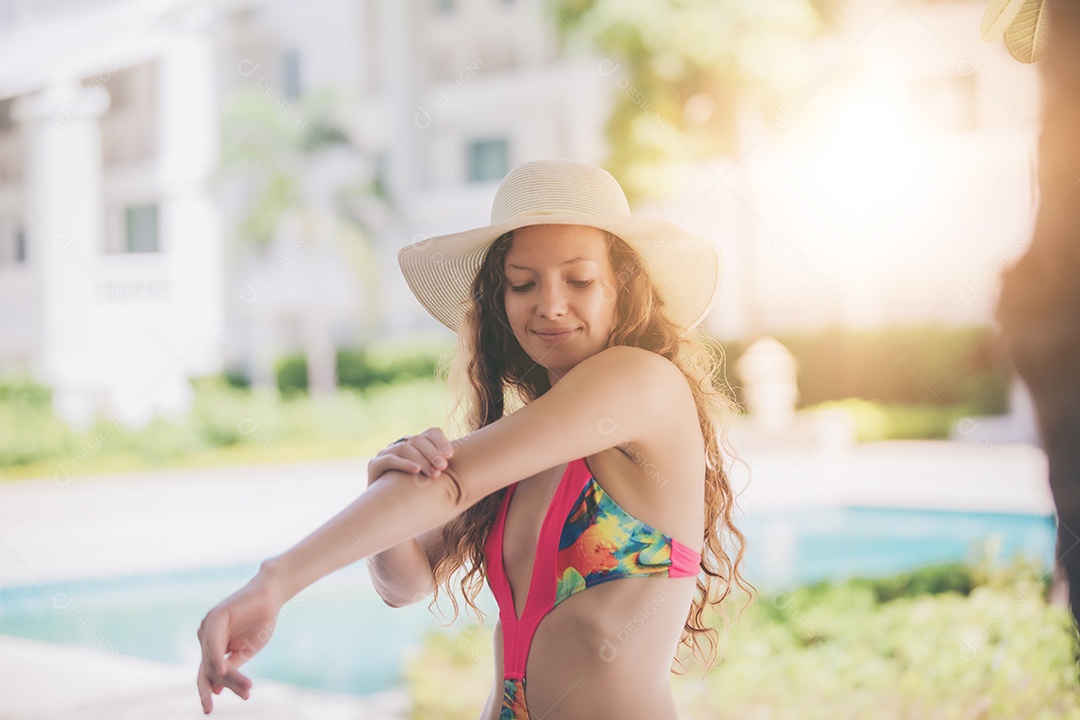 As mulheres usam biquínis e bebem coquetéis no verão quente