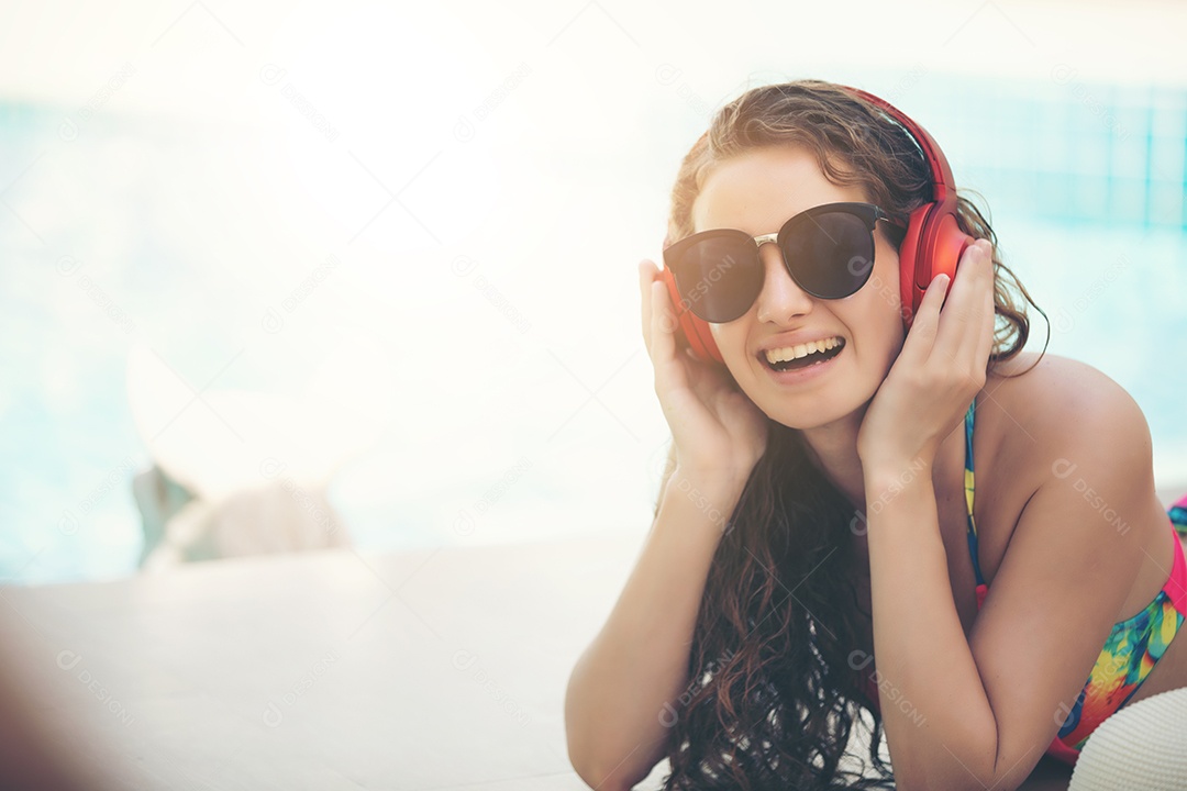 As mulheres usam biquínis e bebem coquetéis no verão quente