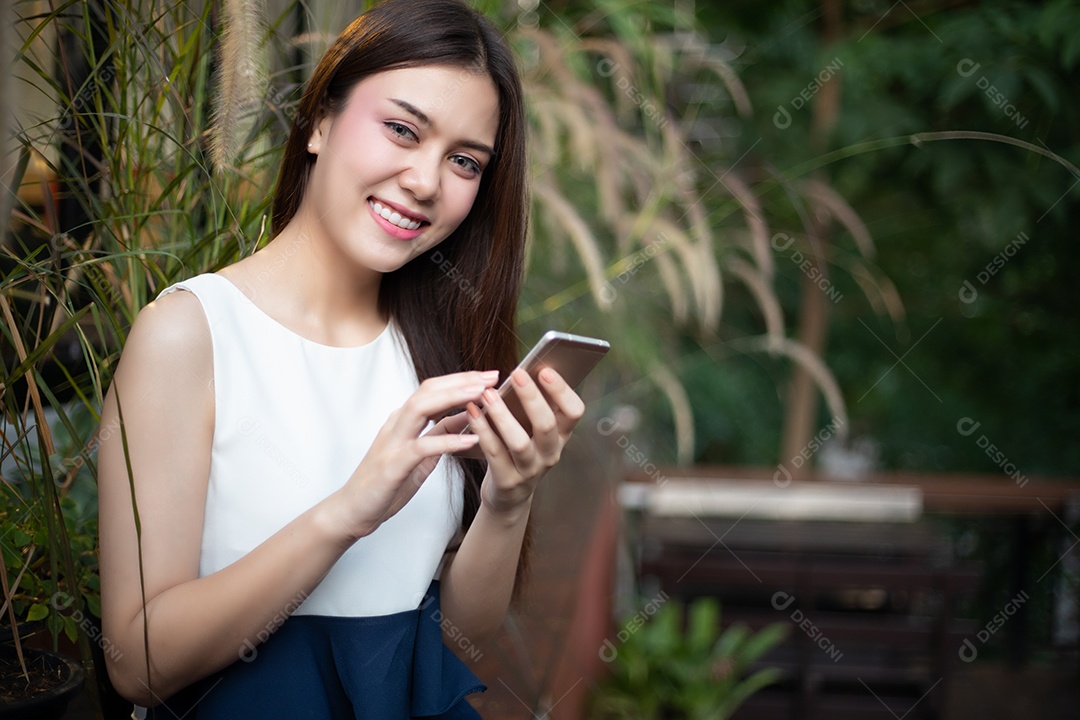 Empresários e mulheres da Ásia estão usando telefones inteligentes móveis e sensíveis ao toque