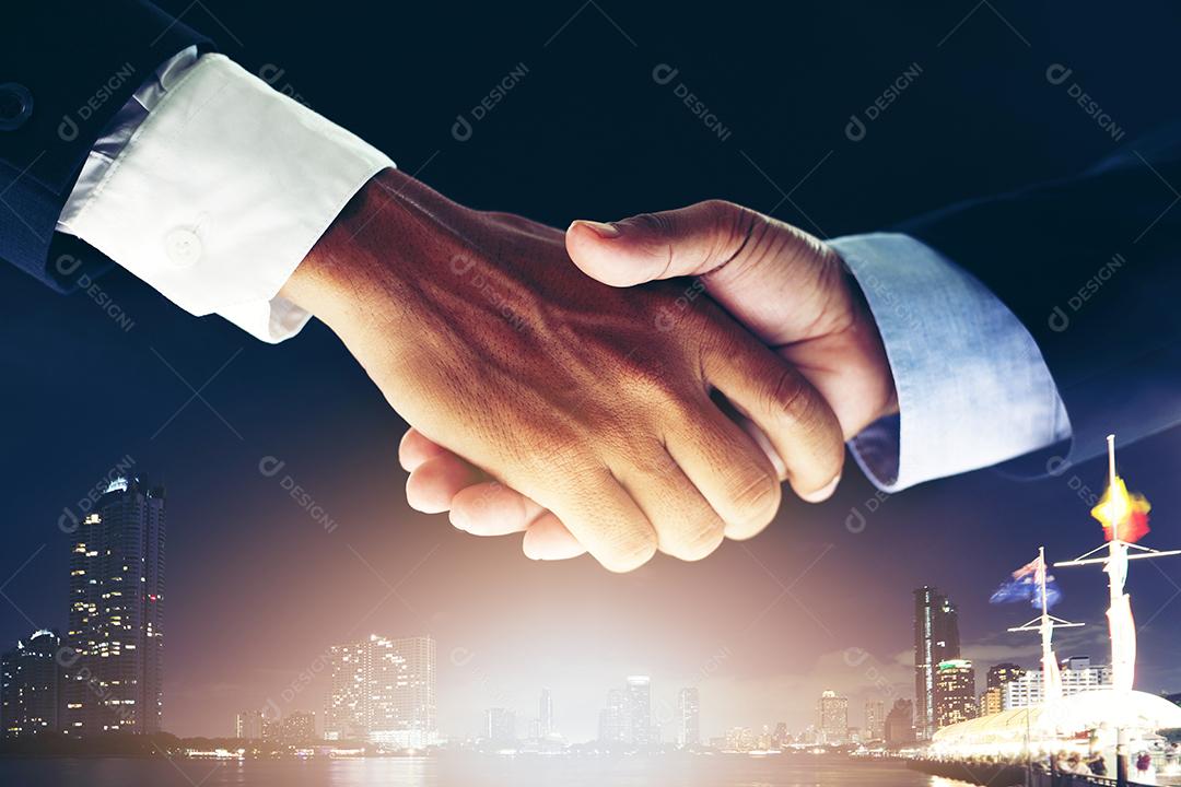 Conceito de reunião de parceria de negócios e aperto de mão de negócios para o sucesso do acordo de investimento e fundo noturno da cidade