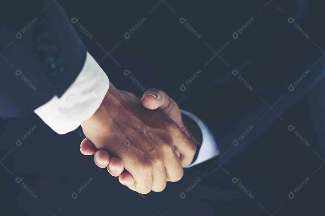 Concept of business partnership meeting and business handshake for investment deal success on black background