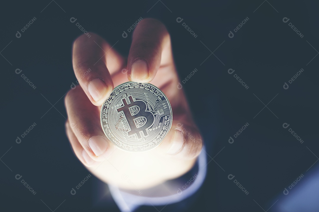 A mão do homem segurando a tira Bitcoins e o novo conceito de dinheiro