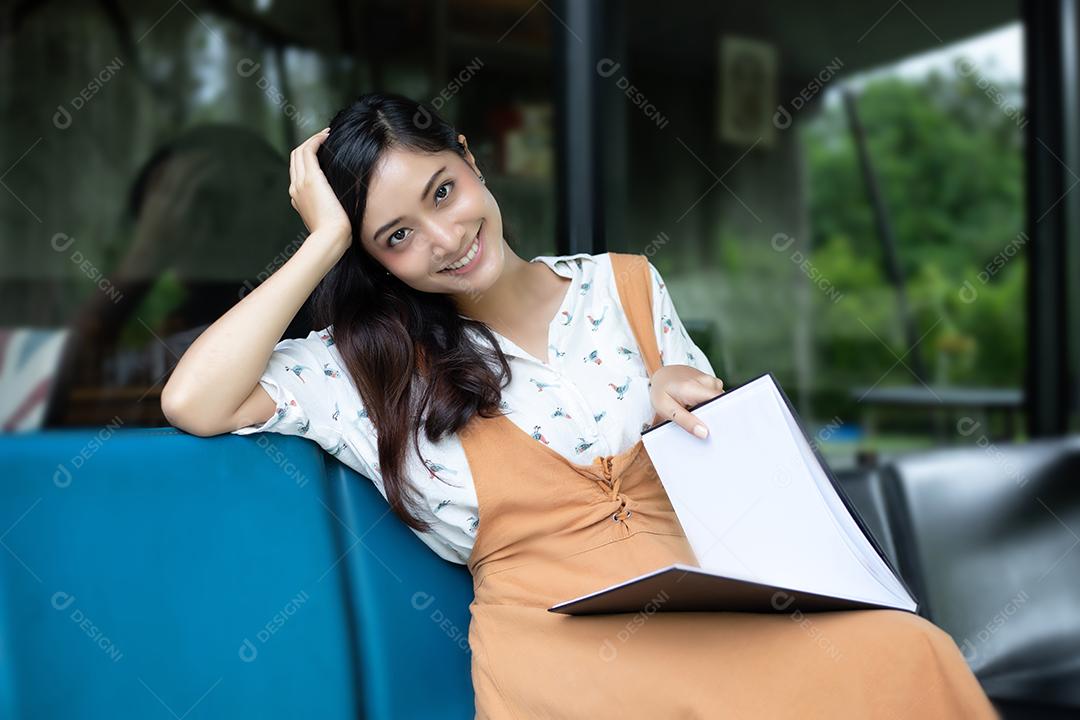 Mulheres asiáticas sorrindo e felizes Relaxando em uma cafeteria depois de trabalhar em um escritório de sucesso.