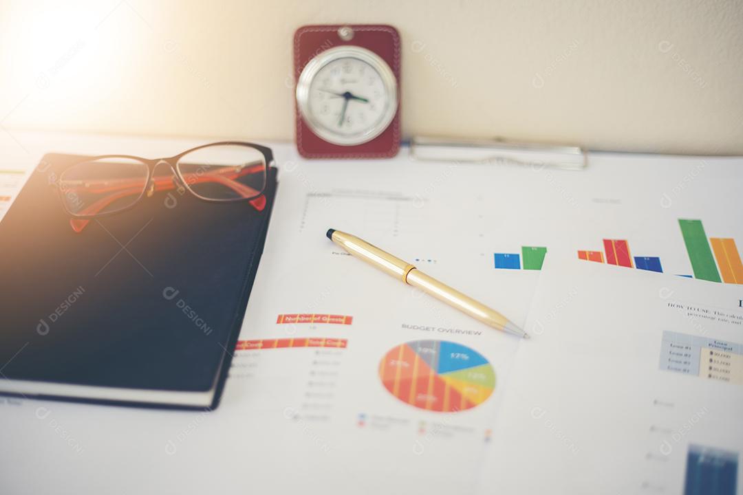 Conceito de negócios de gráficos de trabalho e análise de escritório e relógio na mesa