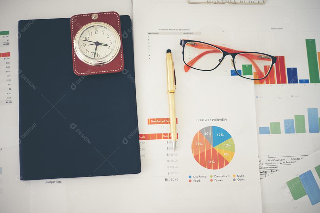 Conceito de negócios de gráficos de trabalho e análise de escritório e relógio na mesa