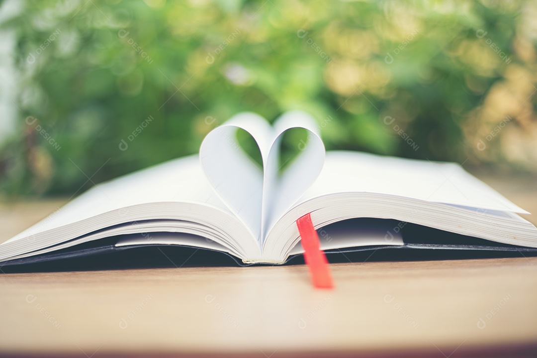 Abra o livro na mesa de madeira no fundo natural. página do livro do coração
