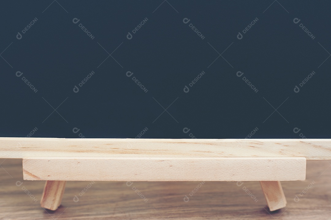 Placa preta no tampo da mesa de madeira com sol e boke de árvore verde borrão