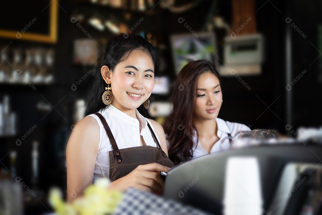 Mulheres asiáticas Barista sorrindo e usando máquina de café no café