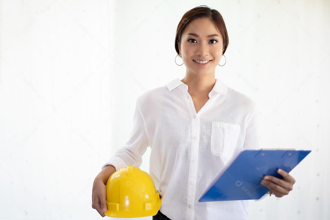 Mulheres asiáticas engenharia inspecionando e trabalhando e segurando plantas no escritório