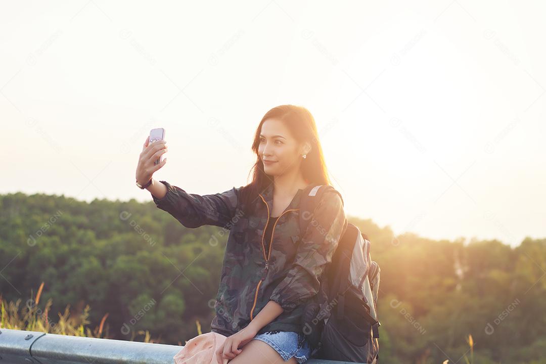 Mulheres asiáticas sorrindo estão tirando fotos e selfie