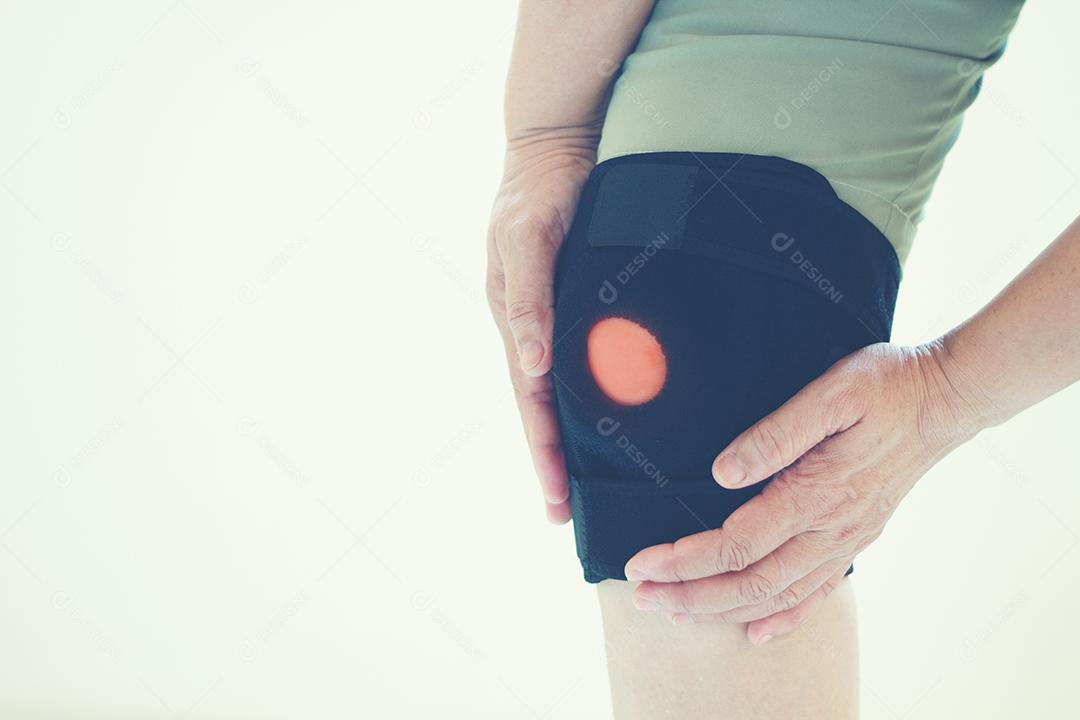 Foco suave de mulheres asiáticas idosas para lesão no joelho em fundo branco